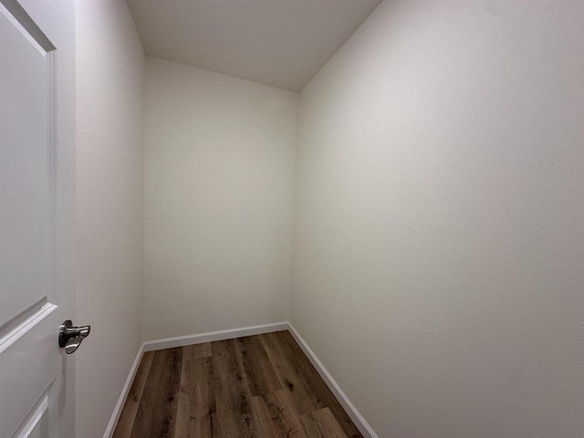 interior space with dark wood-type flooring and vaulted ceiling