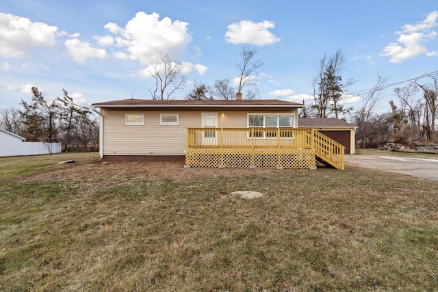 rear view of property featuring a lawn and a wooden deck