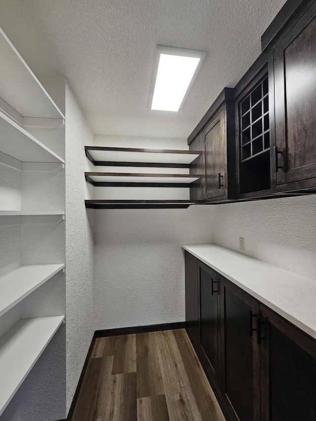 walk in closet with dark hardwood / wood-style floors