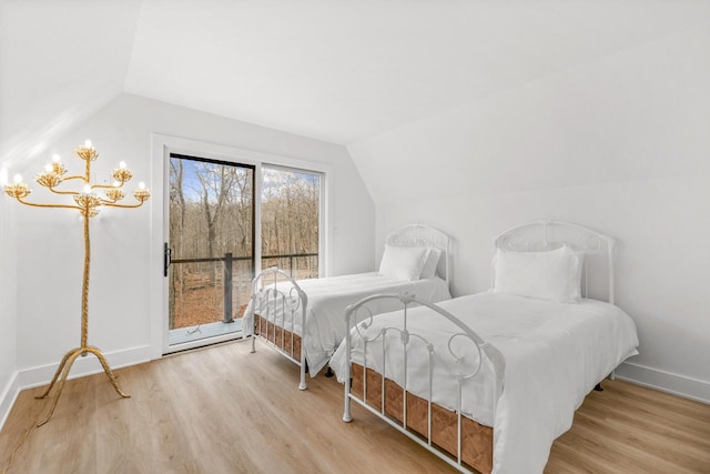 bedroom with light hardwood / wood-style floors and vaulted ceiling