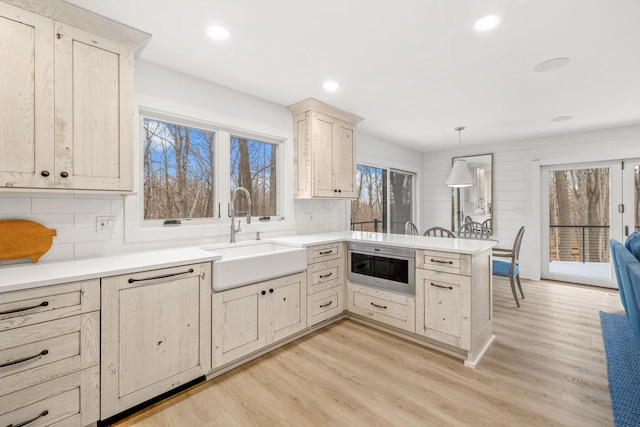 kitchen with pendant lighting, stainless steel microwave, sink, and a wealth of natural light