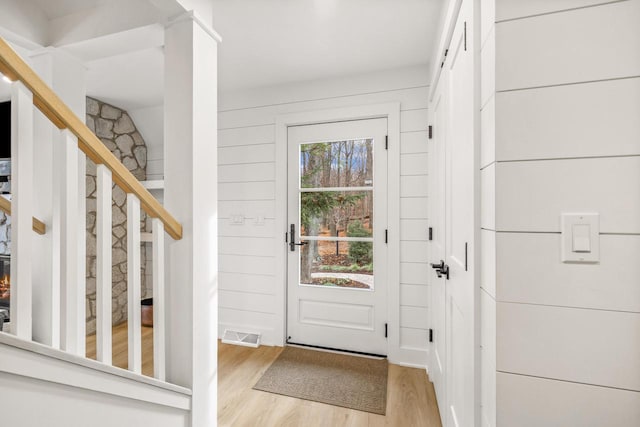 entrance foyer with wood walls and light wood-type flooring