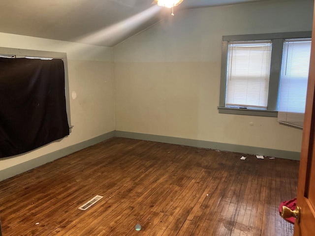 additional living space featuring dark hardwood / wood-style floors and lofted ceiling