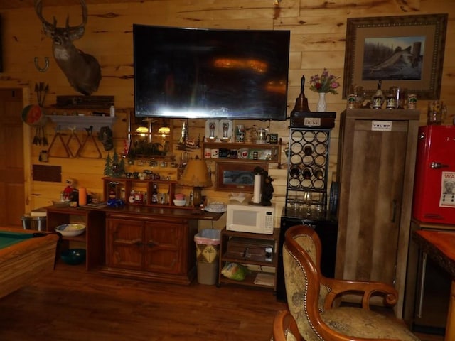 bar with wood walls, wood-type flooring, and billiards