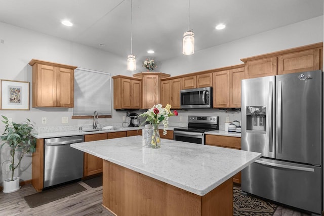 kitchen with sink, stainless steel appliances, dark hardwood / wood-style floors, pendant lighting, and a kitchen island