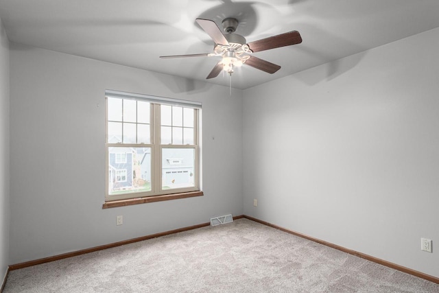 carpeted spare room featuring ceiling fan