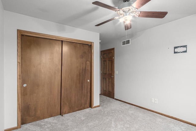 unfurnished bedroom with ceiling fan, a closet, and light carpet