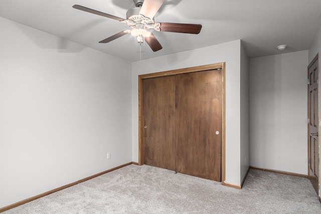 unfurnished bedroom featuring a closet, light colored carpet, and ceiling fan