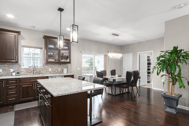 9907 White Fox Ln, Middleton, WI 53562 - kitchen with dark wood-style floors, glass insert cabinets, dark brown cabinets, decorative backsplash, and recessed lighting