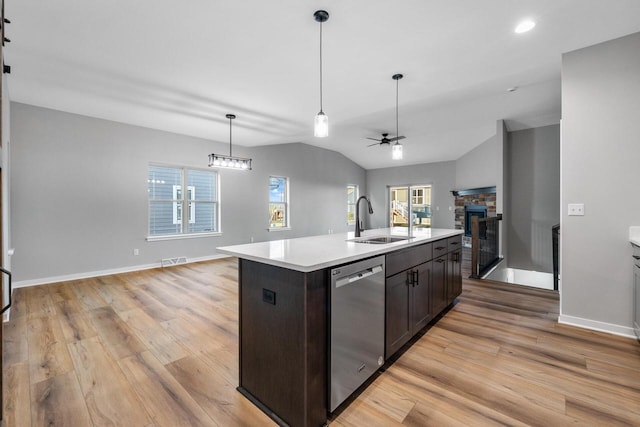 kitchen featuring dishwasher, sink, light hardwood / wood-style flooring, an island with sink, and lofted ceiling