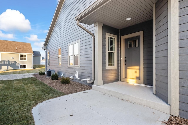 doorway to property with a yard and central air condition unit