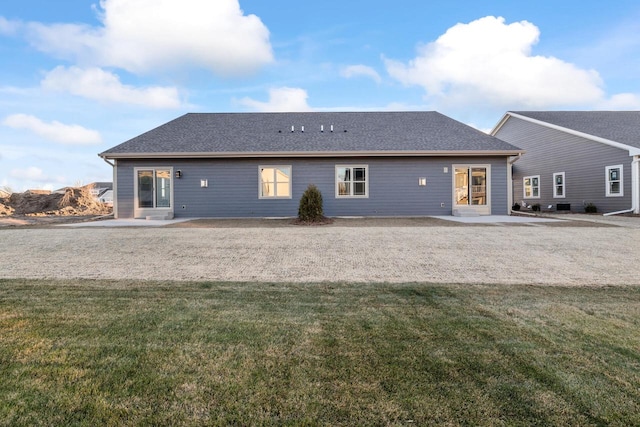 back of property featuring a patio area and a lawn