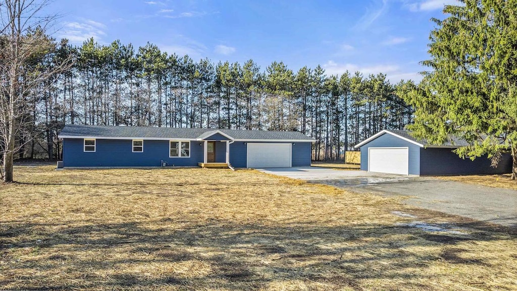 single story home featuring a garage and an outbuilding