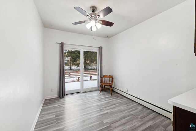 121 E Bayfield St, Washburn, WI 54891 - empty room featuring light wood-type flooring, a baseboard radiator, and ceiling fan