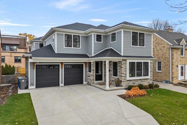 view of front of house with covered porch, a front yard, and a garage