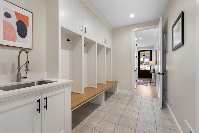 mudroom with light hardwood / wood-style flooring and sink