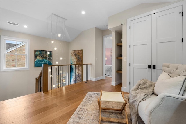 living area with vaulted ceiling and light hardwood / wood-style flooring