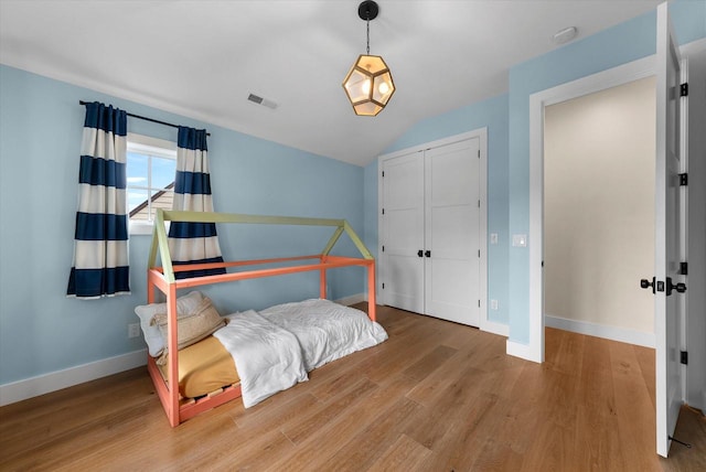 bedroom featuring wood-type flooring and vaulted ceiling