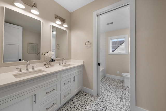 full bathroom with tile patterned flooring, vanity,  shower combination, and toilet