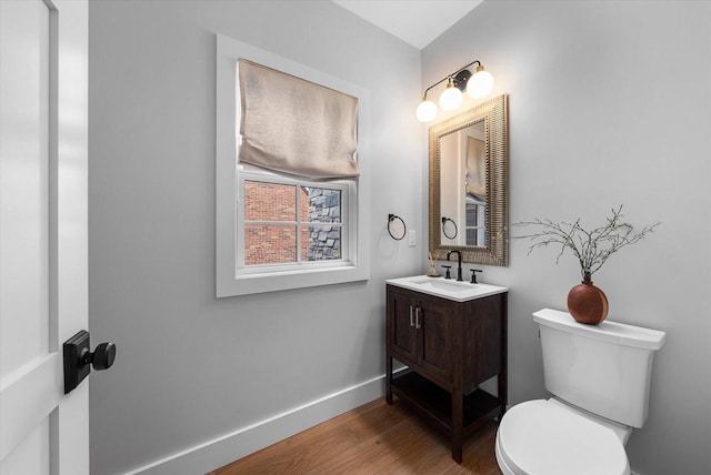 bathroom with hardwood / wood-style floors, vanity, and toilet