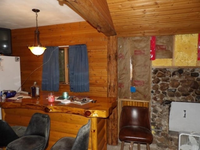 interior space featuring beamed ceiling, white refrigerator, decorative light fixtures, and wooden walls