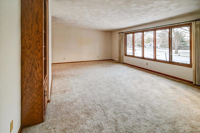 carpeted empty room with a textured ceiling