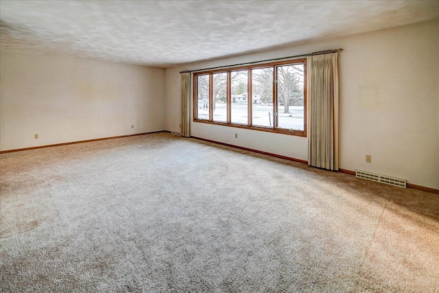 carpeted spare room with a textured ceiling