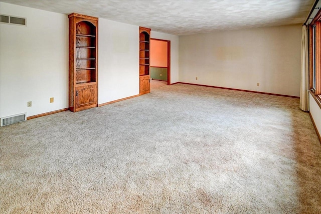 carpeted empty room featuring a textured ceiling