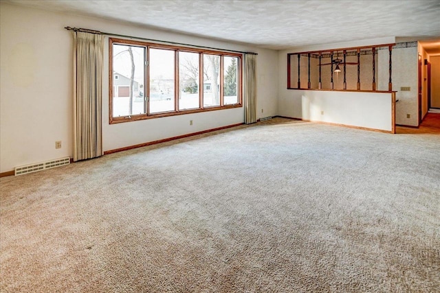 carpeted spare room featuring a textured ceiling