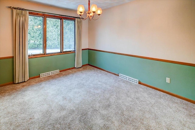 carpeted spare room featuring a notable chandelier