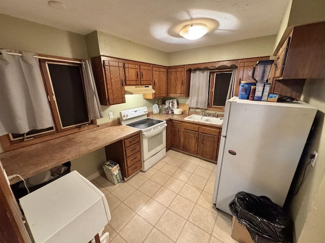 kitchen with white appliances, sink, and light tile patterned floors