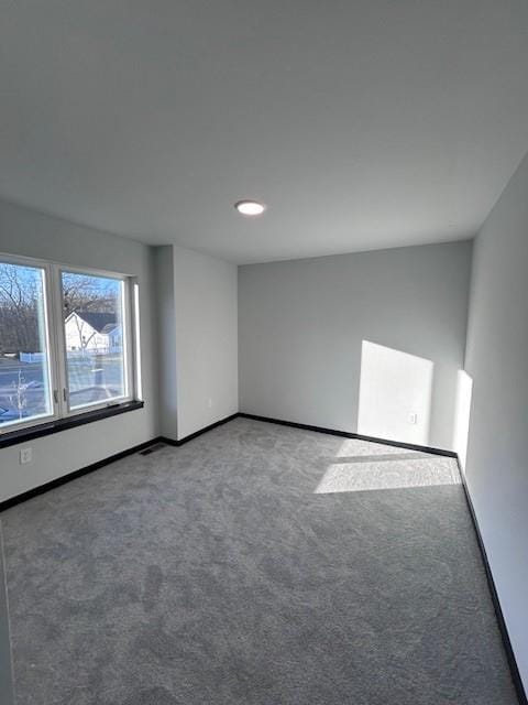 carpeted empty room featuring baseboards