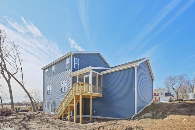 back of property featuring a sunroom and stairs