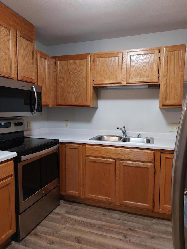 kitchen with wood-type flooring, sink, and appliances with stainless steel finishes