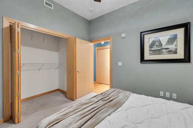 bedroom featuring light colored carpet and a closet