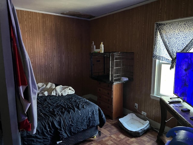 bedroom with wood walls, parquet flooring, and ornamental molding