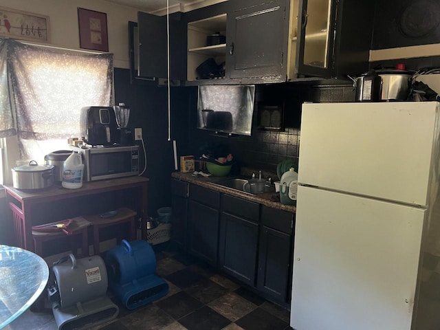 kitchen featuring tasteful backsplash, sink, and white refrigerator