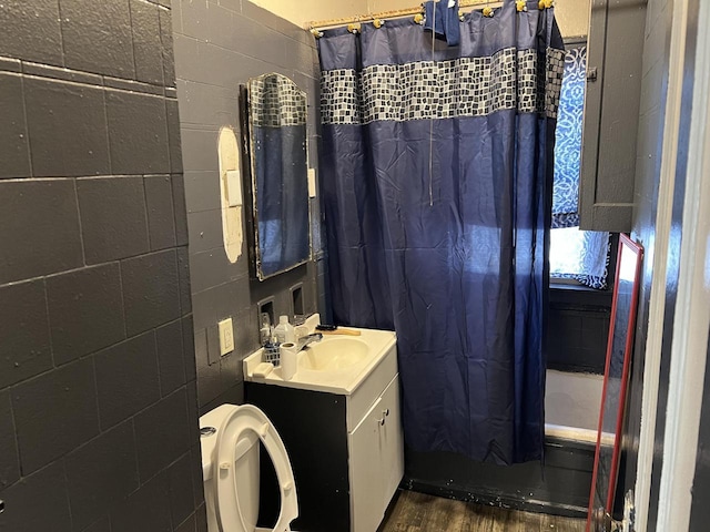 full bathroom featuring hardwood / wood-style flooring, vanity, toilet, and shower / bathtub combination with curtain