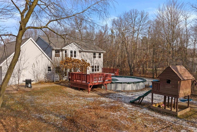 rear view of property with a swimming pool side deck and a playground