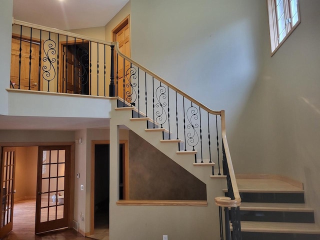 stairs with wood-type flooring and french doors