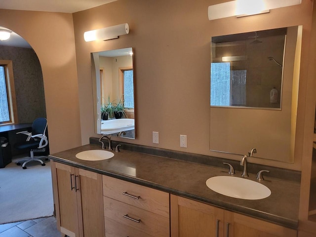 bathroom with tile patterned flooring, vanity, and walk in shower