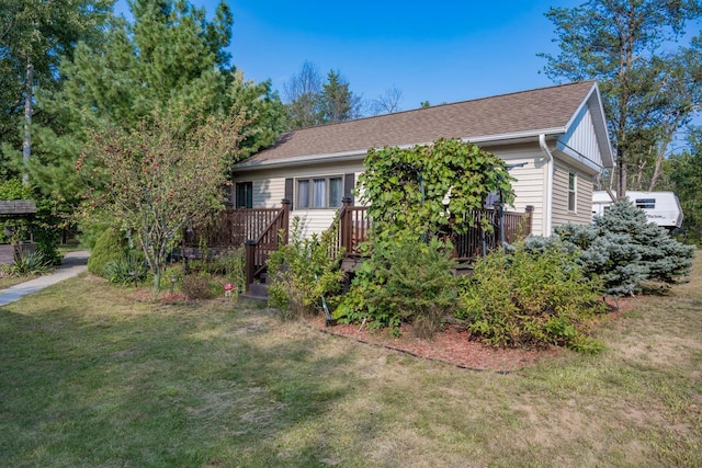 view of front of home with a wooden deck and a front yard