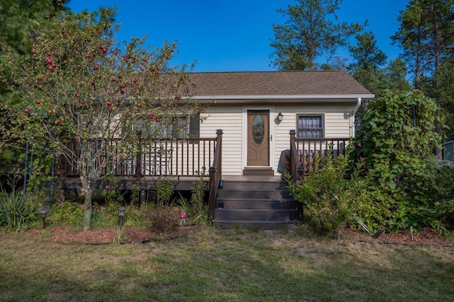 view of front facade with a front lawn and a wooden deck