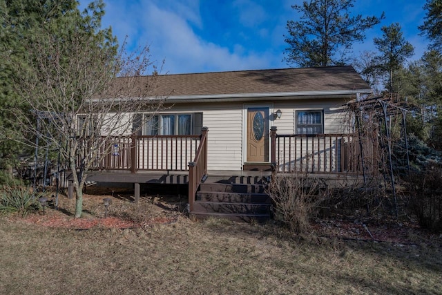 view of front of house featuring a front lawn and a wooden deck