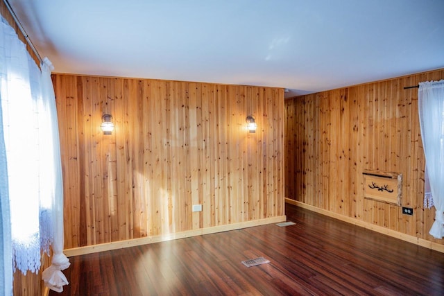 empty room with wooden walls and wood-type flooring