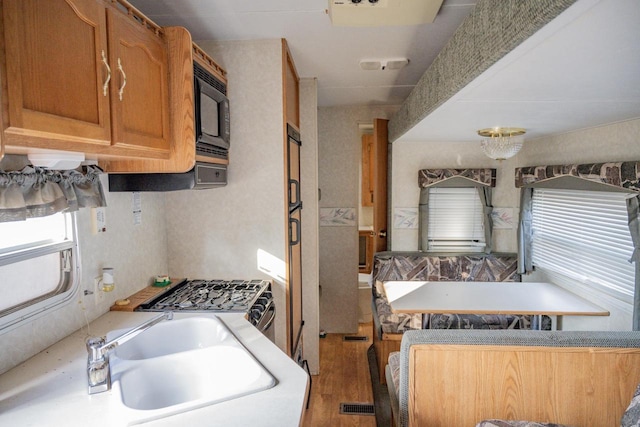 kitchen featuring light hardwood / wood-style floors, sink, and black microwave