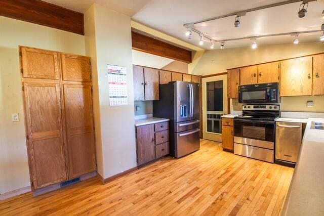 kitchen with appliances with stainless steel finishes, track lighting, light hardwood / wood-style flooring, and beam ceiling