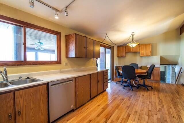 kitchen with pendant lighting, light wood-type flooring, stainless steel dishwasher, and a healthy amount of sunlight