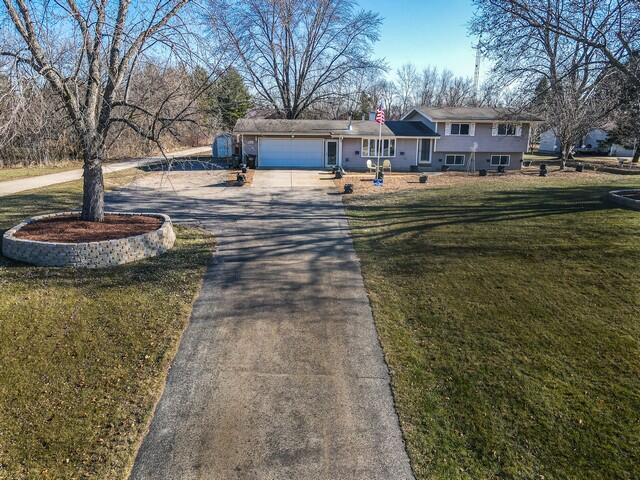 view of front of property featuring a garage and a front lawn