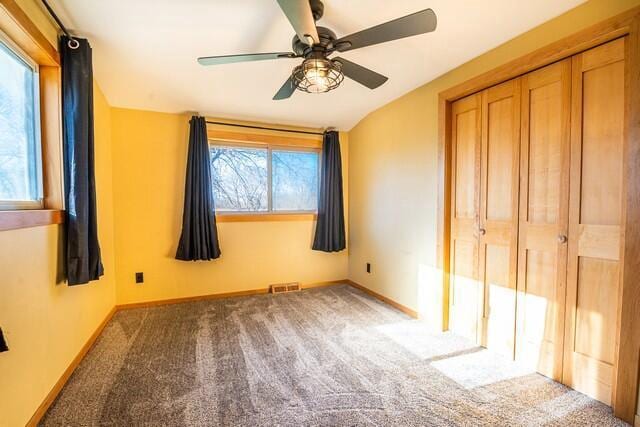 unfurnished bedroom featuring a closet, multiple windows, and ceiling fan